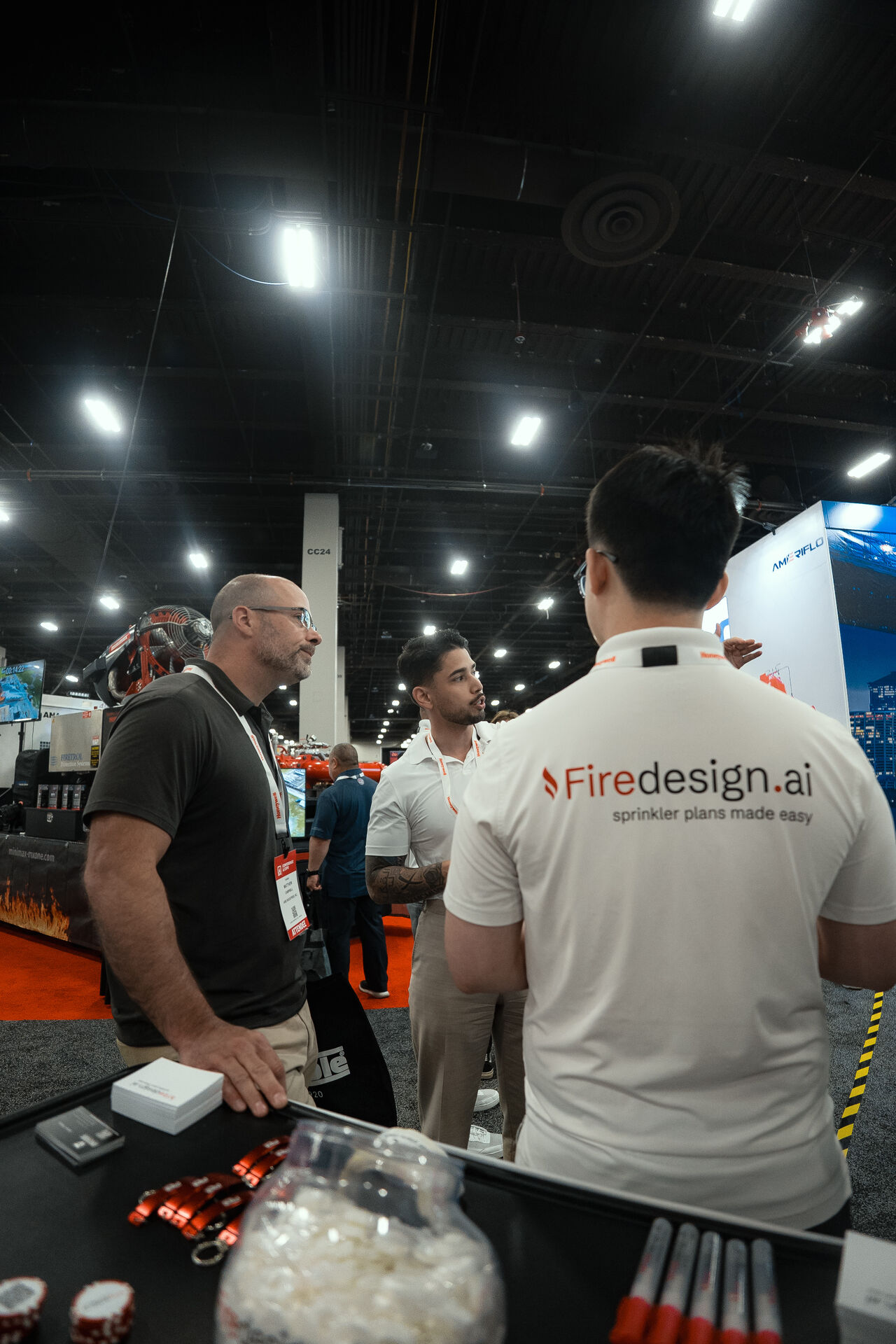 Omar Hafez talking with attendees at the Firedesign.ai trade show booth