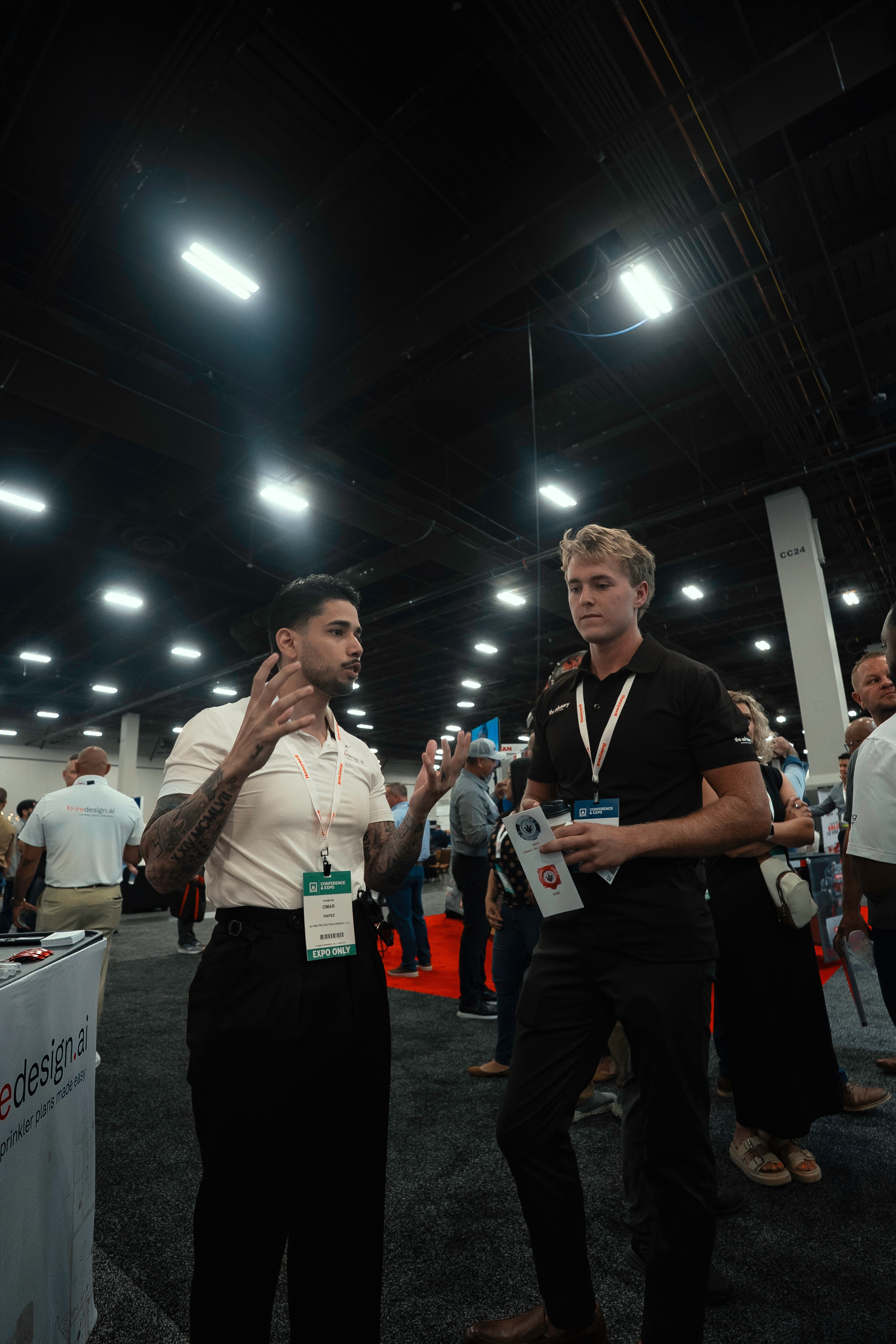 Omar Hafez in conversation with a colleague on the trade show floor