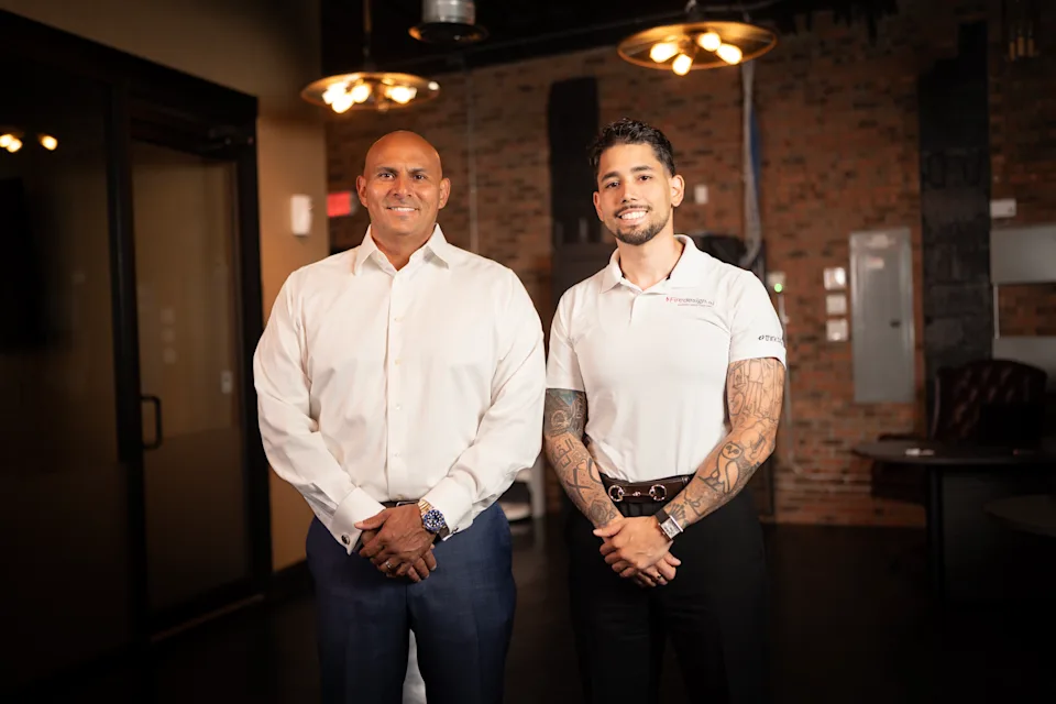Omar Hafez standing with a colleague in a brick-walled office