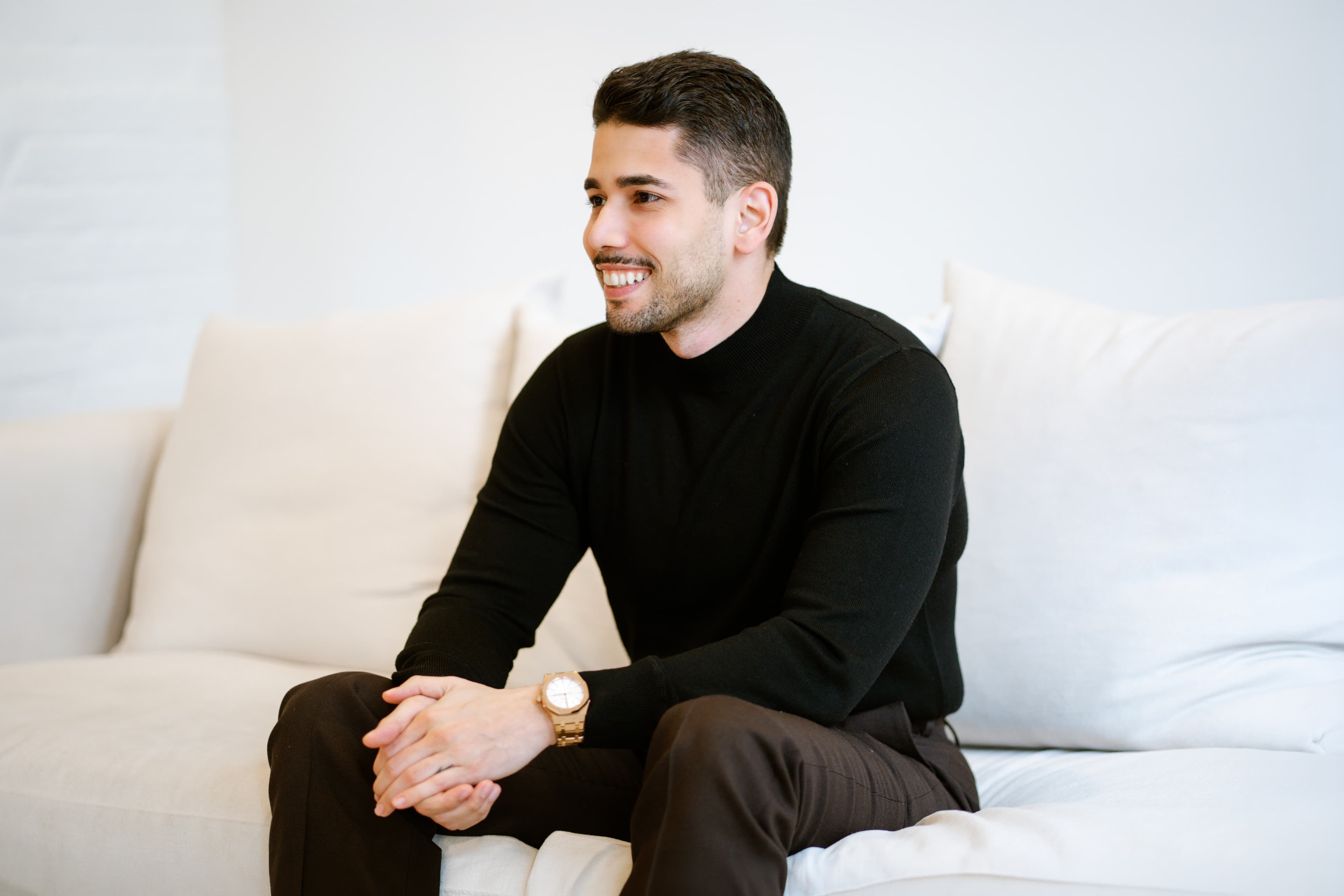 Omar Hafez seated on a white couch